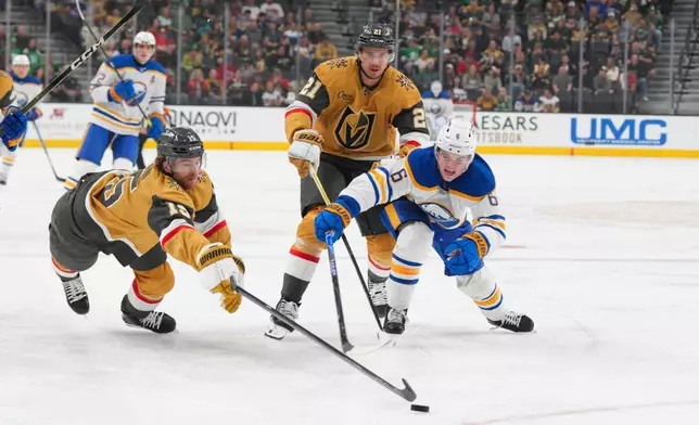 Vegas Golden Knights defenseman Noah Hanifin (15) and center Brett Howden (21) chase after the puck against Buffalo Sabres left wing Zach Benson (6) during the first period of an NHL hockey game Tuesday, March 17, 2026, in Las Vegas. (AP Photo/Candice Ward)