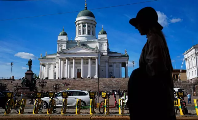 FILE - A woman walks past the Helsinki Cathedral in Helsinki, May 29, 2023. (AP Photo/Pavel Golovkin, File)
