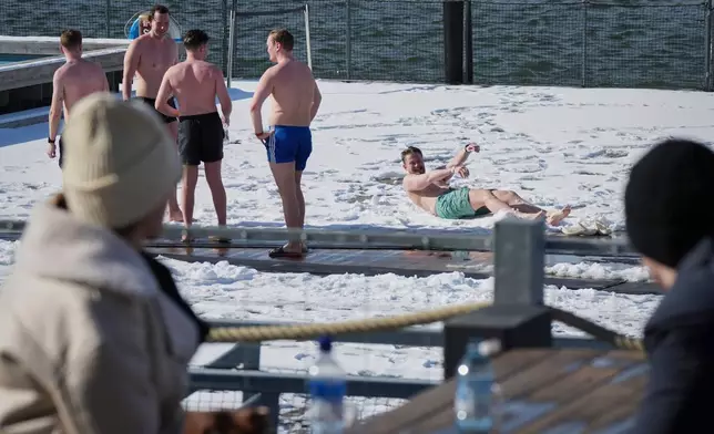 FILE - People spend time outside after using the sauna of the public bath in Helsinki, March 15, 2025. (AP Photo/Sergei Grits, File)