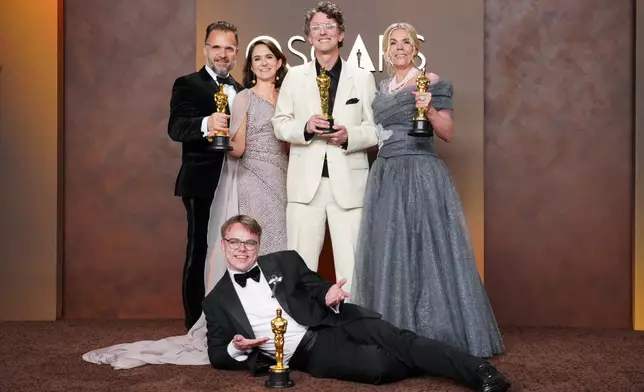 Pavel Talankin, front center, and Radovan Sibrt, top left, Alzbeta Karaskova, David Borenstein, and Helle Faber, winners of the award for documentary feature film for "Mr. Nobody against Putin," pose in the press room at the Oscars on Sunday, March 15, 2026, at the Dolby Theatre in Los Angeles. (Photo by Jordan Strauss/Invision/AP)