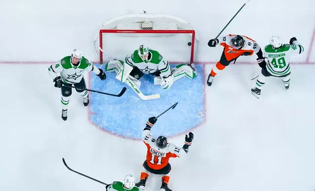 Philadelphia Flyers right winger Travis Konecny (11) reacts to his goal against Dallas Stars goalie Casey DeSmith, top center left, during the second period of an NHL hockey game, Sunday, March 29, 2026, in Philadelphia. (AP Photo/Chris Szagola)