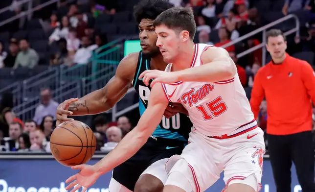 Houston Rockets guard Reed Sheppard (15) knocks away the ball from Portland Trail Blazers guard Scoot Henderson (00) during the first half of an NBA basketball game Friday March 6, 2026, in Houston. (AP Photo/Michael Wyke)