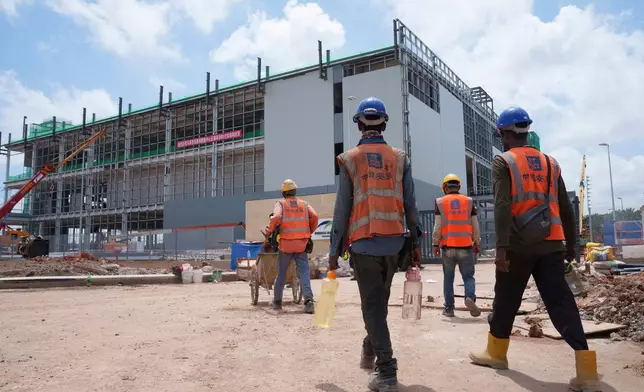 FILE -Construction workers walk to a data center building under construction in Sedenak Tech Park in Johor state of Malaysia, Sept. 27, 2024. (AP Photo/Vincent Thian, File)