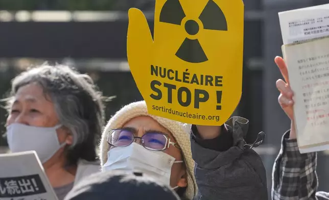 FILE -Protesters hold a sign during a rally against the restart of the No. 6 reactor at the Kashiwazaki-Kariwa nuclear power plant, in front of Tokyo Electric Power Company Holdings (TEPCO) headquarters in Tokyo, Jan. 19, 2026. (AP Photo/Eugene Hoshiko, File)