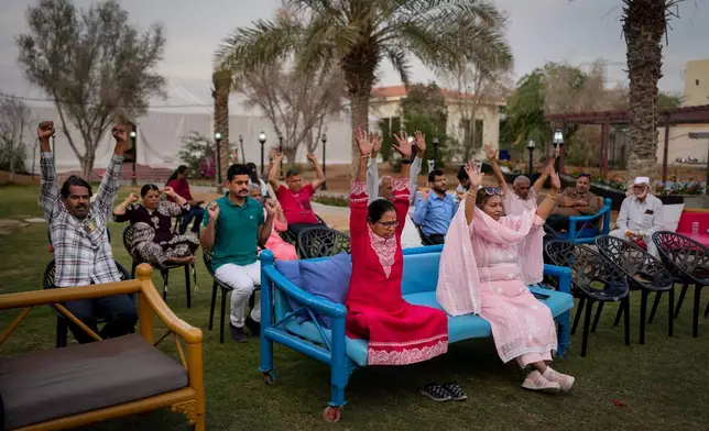 Stranded Indian travelers participate in a yoga session at a farmhouse owned by an Indian businessman, now converted into a shelter in Ajman, near Dubai, United Arab Emirates, Saturday, March 7, 2026. (AP Photo/Altaf Qadri)