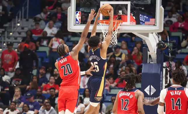 New Orleans Pelicans forward Trey Murphy III (25) gets past Washington Wizards center Alex Sarr (20) for a dunk in the second half of an NBA basketball game in New Orleans, Sunday, March 8, 2026. (AP Photo/Peter Forest)