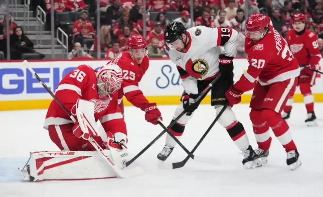 Detroit Red Wings goaltender John Gibson (36) stops a Ottawa Senators right wing Drake Batherson (19) shot as Jacob Bernard-Docker (25) and Albert Johansson (20) defend in the first period of an NHL hockey game Tuesday, March 24, 2026, in Detroit. (AP Photo/Paul Sancya)