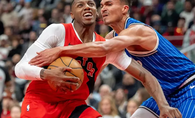 Toronto Raptors forward RJ Barrett (left) is fouled by Orlando Magic forward Tristan da Silva (23) during first half NBA action in Toronto on Sunday, March 29, 2026. (Frank Gunn/The Canadian Press via AP)