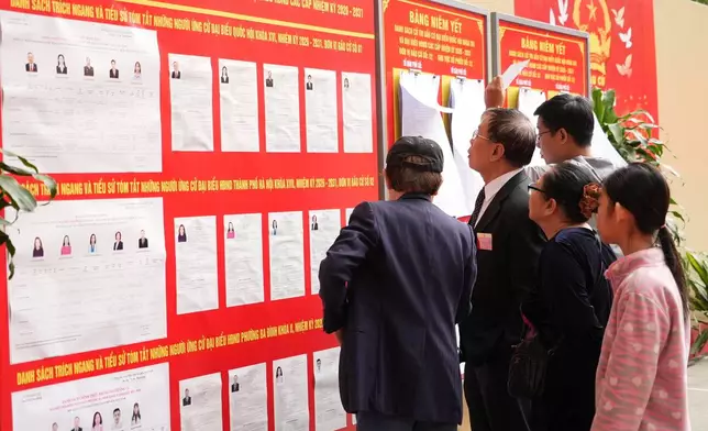 Voters check profiles of candidates before casting ballots to elect representatives in the National Assembly and people's councils in Hanoi, Vietnam, Sunday, March 15, 2026. (AP Photo/Hau Dinh)