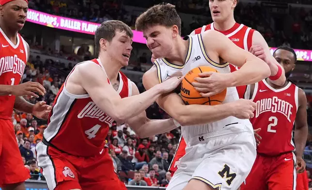 Michigan forward Will Tschetter, right, battles for the ball with Ohio State guard Gabe Cupps during the second half of an NCAA college basketball game in the quarterfinals of the Big 10 Conference tournament, Friday, March 13, 2026, in Chicago. (AP Photo/Nam Y. Huh)