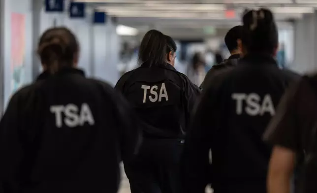 TSA agents walk through a terminal at Los Angeles International Airport in Los Angeles, Friday, March 27, 2026. (AP Photo/Jae C. Hong)