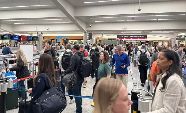 Travelers stand in a TSA checkpoint line at Hartsfield–Jackson Atlanta International Airport on Friday, March 27, 2026. (AP Photo/Emilie Megnien)