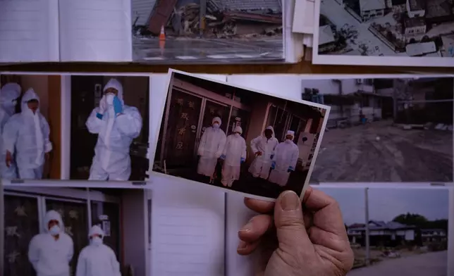 Tomoko Kobayashi holds a photograph taken by her late husband showing her with relatives outside their inn in the summer of 2011, when they briefly returned after evacuating following the March 11, 2011 disaster, in Odaka, Friday, Feb. 13, 2026. (AP Photo/Louise Delmotte)