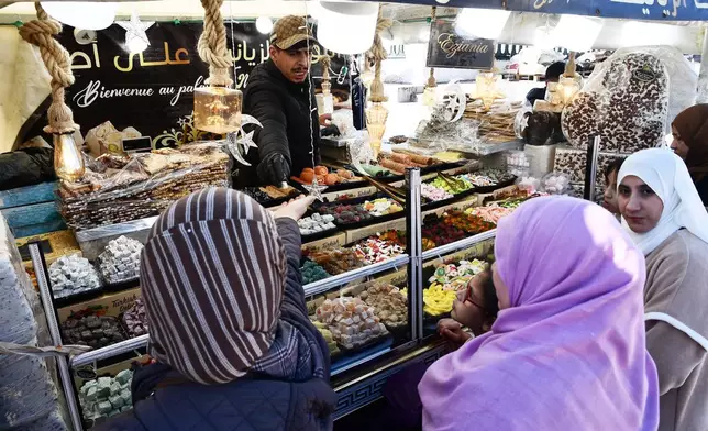 People stock up on food at a market in Algiers, Algeria, Thursday, Feb. 17, 2026. (AP Photo/Fateh Guidoum)