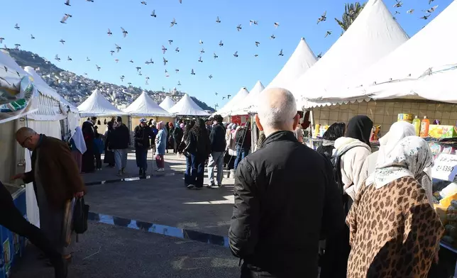 People walk at a market in Algiers, Algeria, Thursday, Feb. 17, 2026. (AP Photo/Fateh Guidoum)