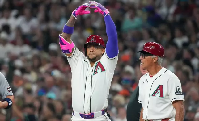 Arizona Diamondbacks first base coach Dave McKay, right, looks on Ketel Marte gestures after hitting a single against the Detroit Tigers during the first inning of an opening-day baseball game Monday, March 30, 2026, in Phoenix. (AP Photo/Darryl Webb)