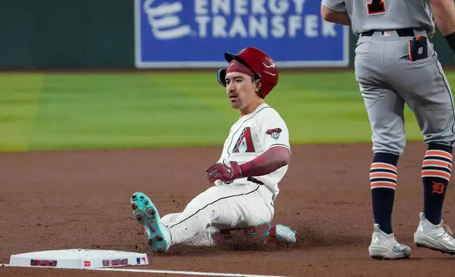 Arizona Diamondbacks' Corbin Carroll (7) slides into third base after hitting a triple against the Detroit Tigers during the first inning of an opening-day baseball game Monday, March 30, 2026, in Phoenix. (AP Photo/Darryl Webb)