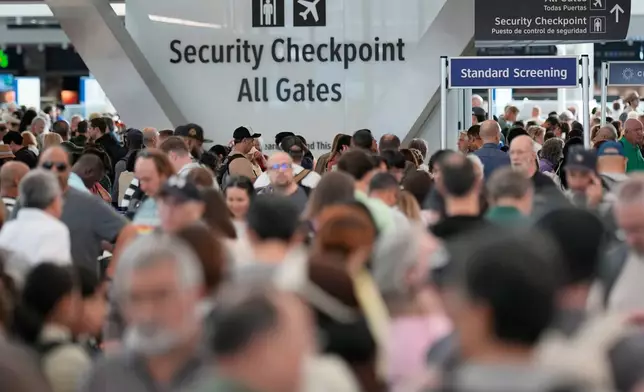 Passengers wait in a security checkpoint line at George Bush Intercontinental Airport, Wednesday, March 25, 2026, in Houston. (AP Photo/David J. Phillip)
