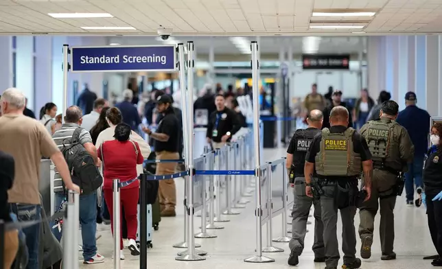 Federal immigration officers walk through a security checkpoint at George Bush Intercontinental Airport, Wednesday, March 25, 2026, in Houston. (AP Photo/David J. Phillip)