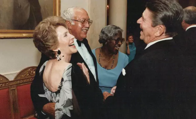 In this photo provided by The White House, John Woodson Ficklin and his wife Nancy talk with President Ronald Reagan and first lady Nancy Reagan as they attend as guests at a State Dinner at the White House on July 19, 1983, in Washington. (The White House via AP)