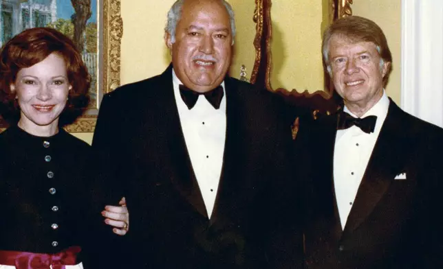 In this undated photo provided by The White House, John Woodson Ficklin poses for a photos with President Jimmy Carter and first lady Rosalynn Carter at the White House in Washington. (The White House via AP)