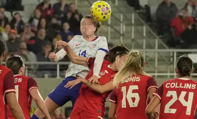 United States' Emily Sonnett (14) heads the ball next to Canada's Julia Grosso (7) in the first half of a SheBelieves Cup women's soccer match in Columbus, Ohio, Wednesday, March 4, 2026. (AP Photo/Sue Ogrocki)