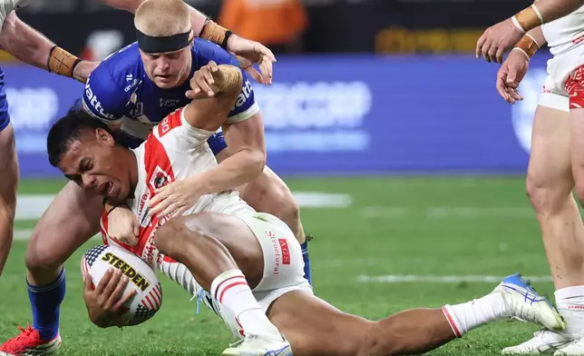 Dragons Luciano Leilua is tackled by Bulldogs Bailey Hayward, top, during the Australia National Rugby League game between the Canterbury Bulldogs and the St George-Illawarra Dragons in Las Vegas, Saturday, Feb. 28, 2026. (AP Photo/Ian Maule)