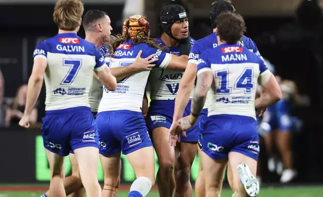 Bulldogs Stephen Crichton, center, is congratulated by teammates after kicking the winning field goal in extra time during the Australia National Rugby League game between the Canterbury Bulldogs and the St George-Illawarra Dragons in Las Vegas, Saturday, Feb. 28, 2026. (AP Photo/Ian Maule)
