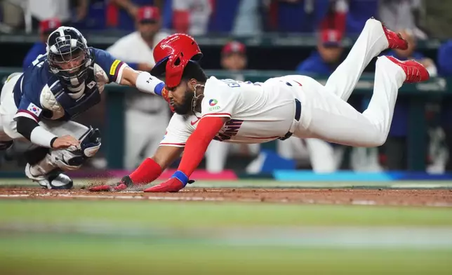 Dominican Republic's Vladimir Guerrero Jr. dives past South Korea catcher Park Dong-won to score on a double by Junior Caminero during the second inning of a World Baseball Classic quarterfinal game, Friday, March 13, 2026, in Miami. (AP Photo/Lynne Sladky)
