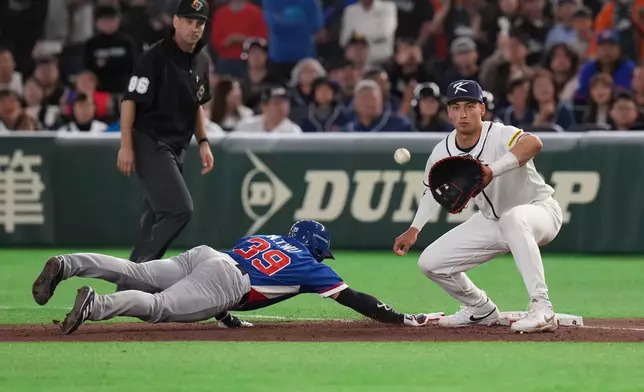 Taiwan's Wu Nien-ting slides into the first base as South Korea's Shay Whitcomb prepares to catch the ball during the seventh inning of a World Baseball Classic game between South Korea and Taiwan on Sunday, March 8, 2026 in Tokyo, Japan. (AP Photo/Eugene Hoshiko)