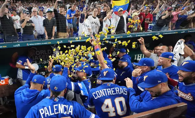 Venezuela team celebrate their victory over Japan after a World Baseball Classic quarterfinal game, Saturday, March 14, 2026, in Miami. (AP Photo/Lynne Sladky)