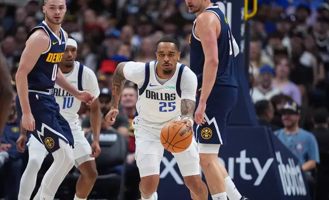 Dallas Mavericks forward P.J. Washington, center, collects a loose ball as Denver Nuggets guard Christian Braun, left, and center Nikola Jokic defend in the first half of an NBA basketball game Wednesday, March 25, 2026, in Denver. (AP Photo/David Zalubowski)