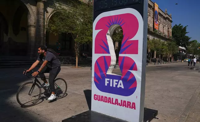 A cyclist rides past an installation promoting the FIFA World Cup 2026 in Guadalajara, Mexico, Wednesday, Feb. 25, 2026. (AP Photo/Marco Ugarte)