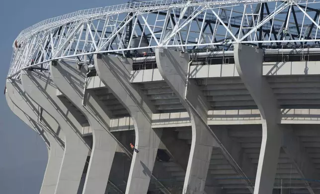 A worker paints a column of the Azteca Stadium 100 days before the opening ceremony of the 2026 FIFA soccer World Cup in Mexico City, Tuesday, March 3, 2026. (AP Photo/Fernando Llano)