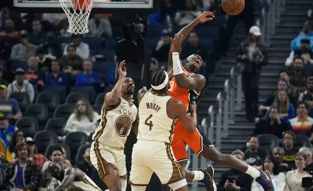 Los Angeles Clippers guard Kris Dunn, right, passes the ball while being defended by Golden State Warriors guard De'Anthony Melton, left, and guard Moses Moody (4) during the first half of an NBA basketball game in San Francisco, Monday, March 2, 2026. (AP Photo/Jeff Chiu)