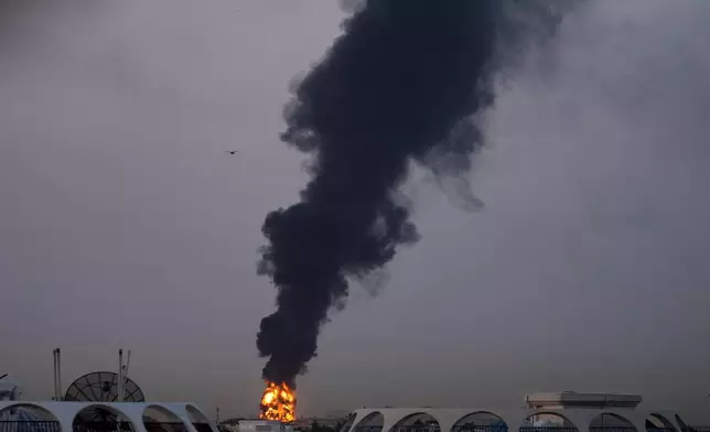 Fire and plumes of smoke rise after a drone struck a fuel tank forcing the temporary suspension of flights. near Dubai International Airport, in United Arab Emirates, early Monday, March 16, 2026. (AP Photo)