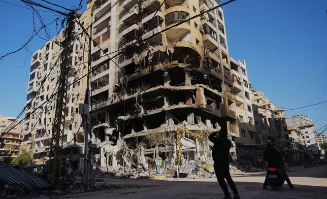 A man photographs a building damaged by an Israeli airstrike in Dahiyeh, Beirut's southern suburbs, Lebanon, Tuesday, March 17, 2026. (AP Photo/Hassan Ammar)