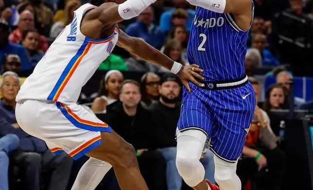 Oklahoma City Thunder guard Shai Gilgeous-Alexander, left, defends against Orlando Magic guard Jevon Carter (2) during the first half of an NBA basketball game, Tuesday, March 17, 2026, in Orlando, Fla. (AP Photo/Kevin Kolczynski)