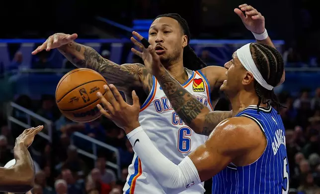 Oklahoma City Thunder forward Jaylin Williams (6) and Orlando Magic forward Paolo Banchero (5) fight for the ball during the first half of an NBA basketball game, Tuesday, March 17, 2026, in Orlando, Fla. (AP Photo/Kevin Kolczynski)