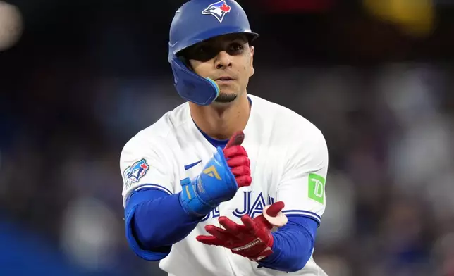 Toronto Blue Jays Andrés Giménez (0) reacts after hitting a triple against the Athletics during the fifth inning of a baseball game in Toronto on Friday, March 27, 2026. (Nathan Denette/The Canadian Press via AP)