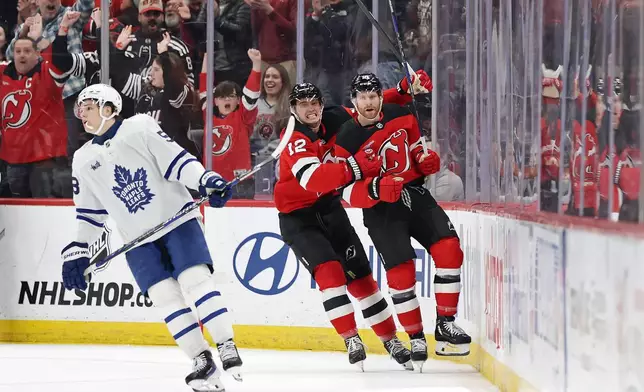 New Jersey Devils right wing Connor Brown, right, is congratulated by New Jersey Devils center Cody Glass (12) after scoring a goal during the third period of an NHL hockey game against the Toronto Maple Leafs, Wednesday, March 4, 2026, in Newark, N.J. (AP Photo/Adam Hunger)