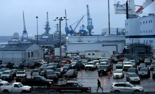FILE — A shipyard worker, below center, walks to his car Tuesday, Jan. 3, 2017, at the end of the workday at Bath Iron Works in Bath, Maine. (AP Photo/Robert F. Bukaty, File)