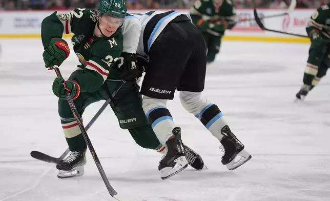 Minnesota Wild right wing Danila Yurov, left, skates with the puck as Utah Mammoth defenseman MacKenzie Weegar defends during the third period of an NHL hockey game, Tuesday, March 10, 2026, in St. Paul, Minn. (AP Photo/Abbie Parr)