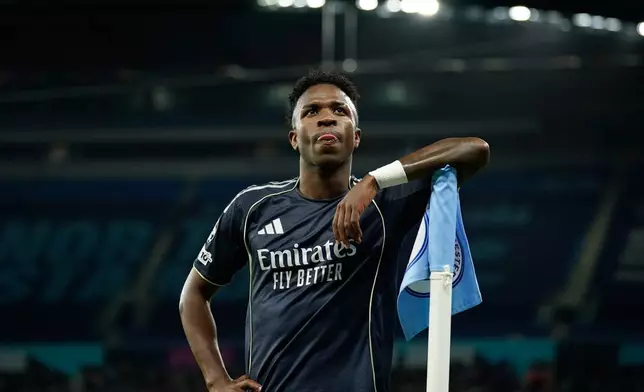 Real Madrid's scorer Vinicius Junior reacts at the corner flag after scoring the opening goal from the penalty spot during the Champions League round of 16 second leg soccer match between Manchester City and Real Madrid in Manchester, Tuesday, March 17, 2026. (AP Photo/Dave Thompson)