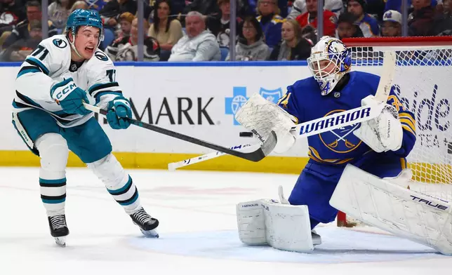 Buffalo Sabres goaltender Alex Lyon, right, stops a tipped shot by San Jose Sharks center Macklin Celebrini (71) during the second period of an NHL hockey game, Tuesday, March 10, 2026, in Buffalo, N.Y. (AP Photo/Jeffrey T. Barnes)