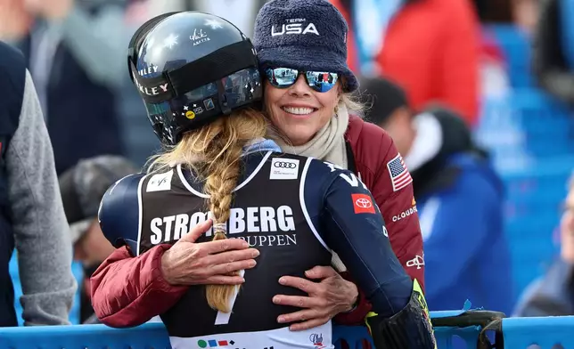 United States' Mikaela Shiffrin, back to camera, is hugged by her mother Eileen at the finish area of an alpine ski, women's giant slalom race, at the Lillehammer World Cup Finals, in Hafjell, Norway, Wednesday, March 25, 2026. (AP Photo/Marco Trovati)