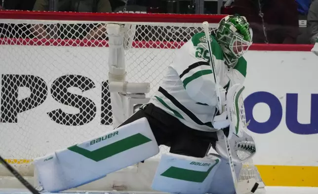 Dallas Stars goaltender Jake Oettinger makes a stick save in the second period of an NHL hockey game against the Colorado Avalanche Wednesday, March 18, 2026, in Denver. (AP Photo/David Zalubowski)