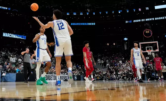 Duke forward Cameron Boozer (12) reaches for the ball as time expires during the second half in the Sweet 16 of the NCAA college basketball tournament against St. John's, Friday, March 27, 2026, in Washington. (AP Photo/Stephanie Scarbrough)