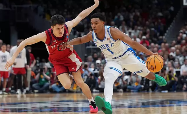 Duke guard Caleb Foster (1) drives past St. John's guard Dylan Darling (0) during the second half in the Sweet 16 of the NCAA college basketball tournament, Friday, March 27, 2026, in Washington. (AP Photo/Stephanie Scarbrough)