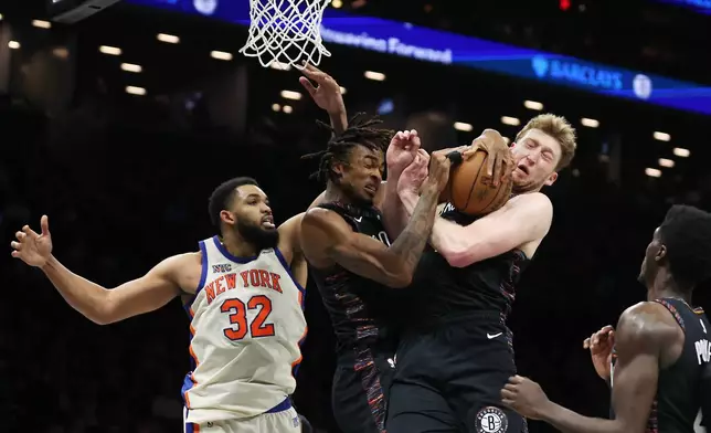 Brooklyn Nets center Nic Claxton, left, and teammate Danny Wolf, right, both go for the rebound during the second half of an NBA basketball game against the New York Knicks, Friday, March 20, 2026, in New York. (AP Photo/Heather Khalifa)